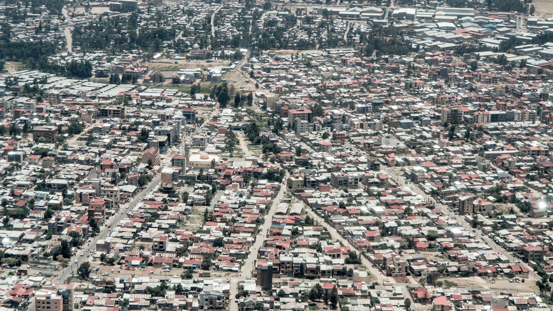 A cityscape with numerous buildings and trees, reflecting the urban environment of Addis Ababa.