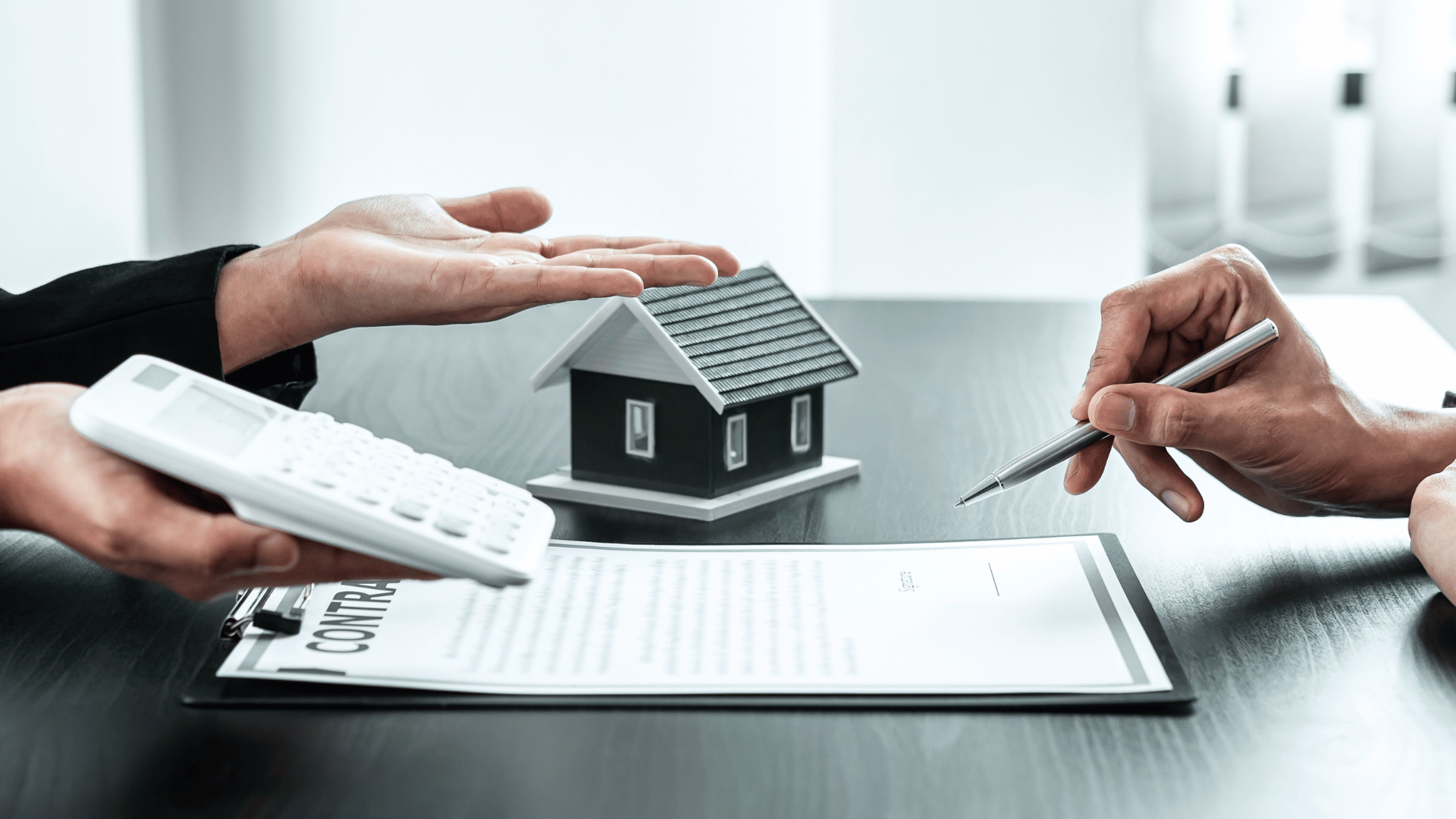 Two people examining a house model and using a calculator to determine the cost in Addis Ababa.